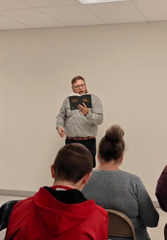 A brother leading the congregation in song from the hymnal